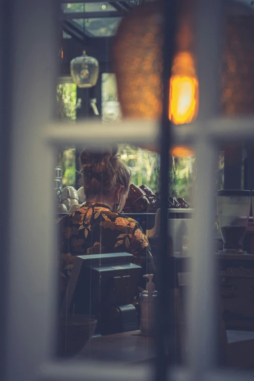 someone sits in a restaurant while looking out the window