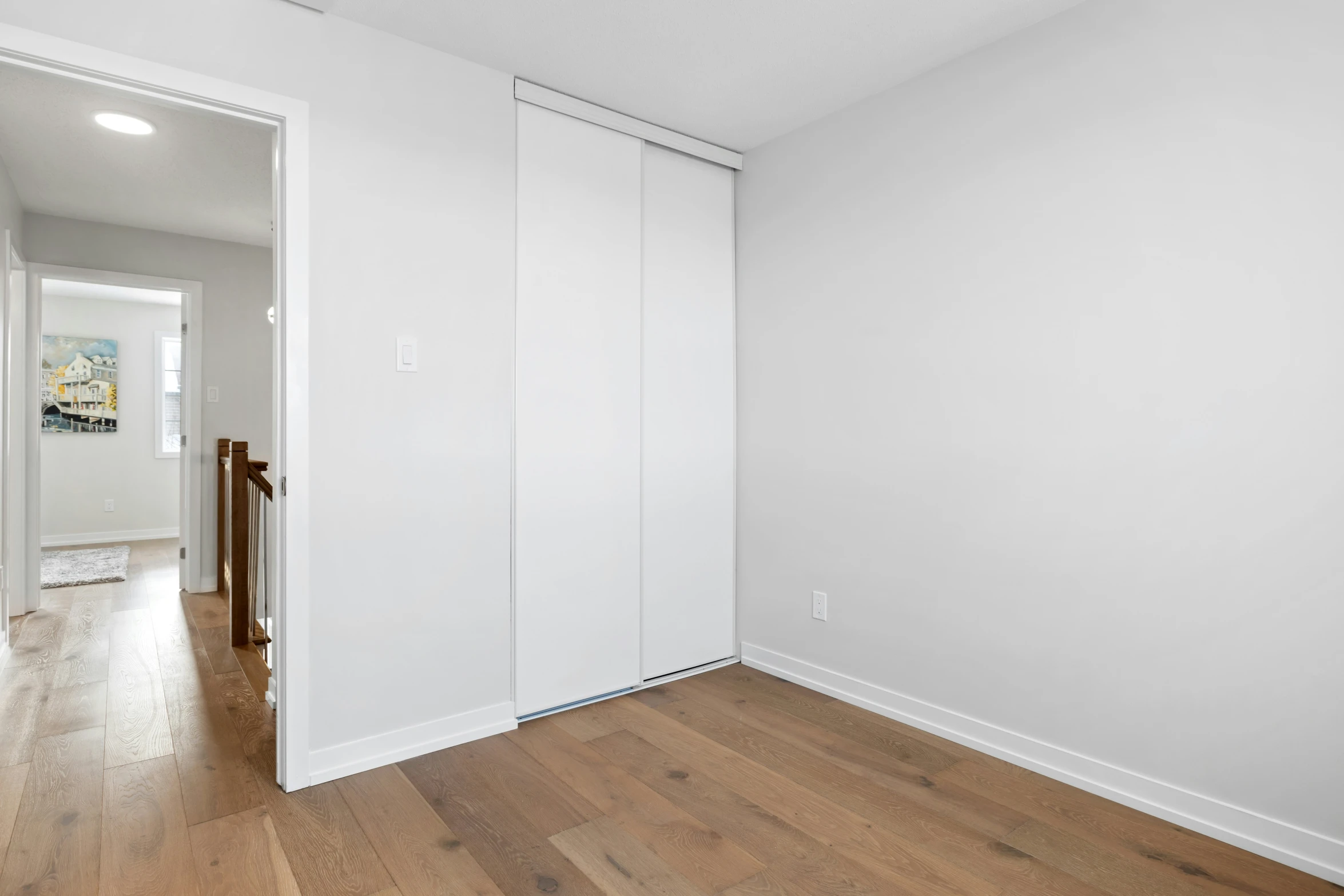 a white room with a sliding door and hard wood floor