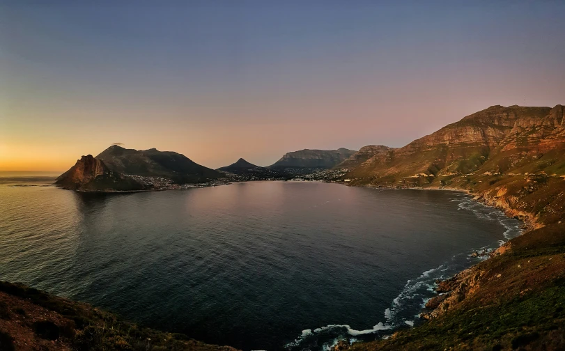 there is a large body of water with mountains in the background