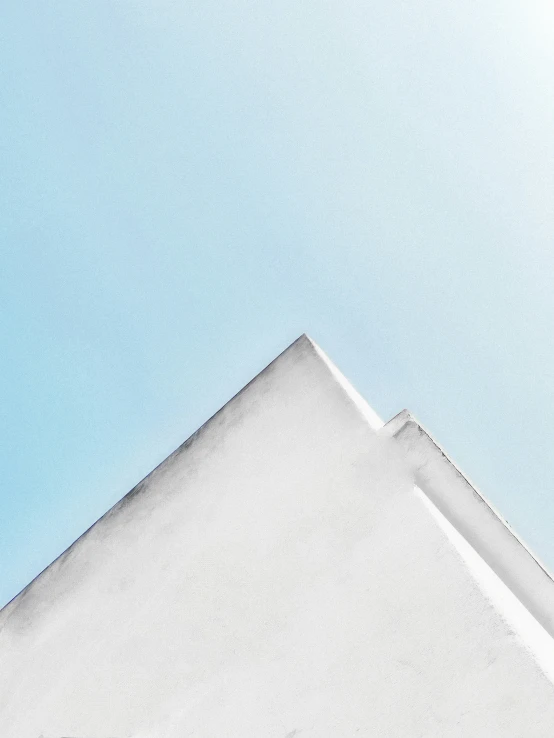 a bird flies near a building with a clear sky