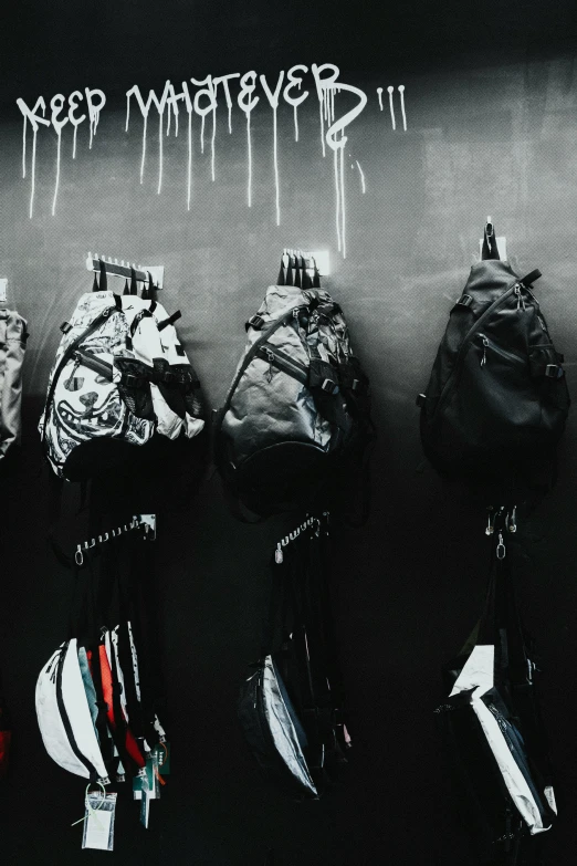 several backpacks are lined up against a wall