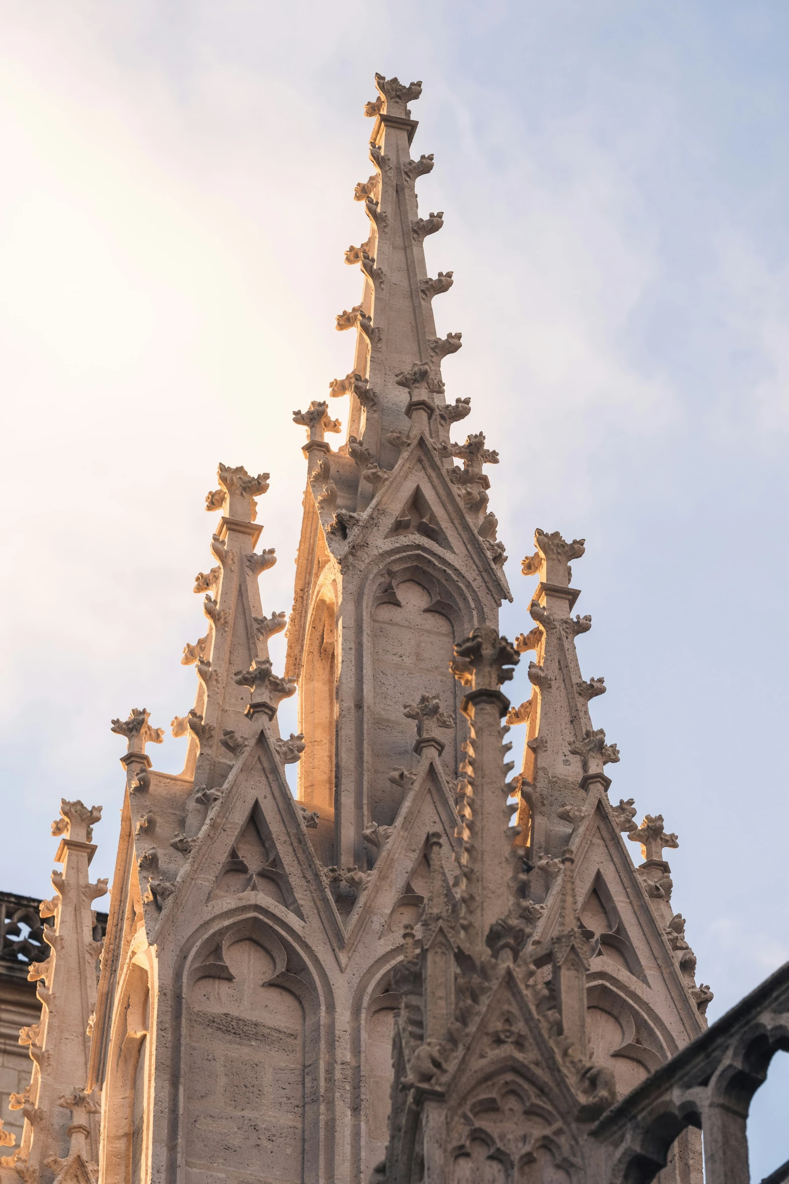 an architectural spire with a clock in front of it