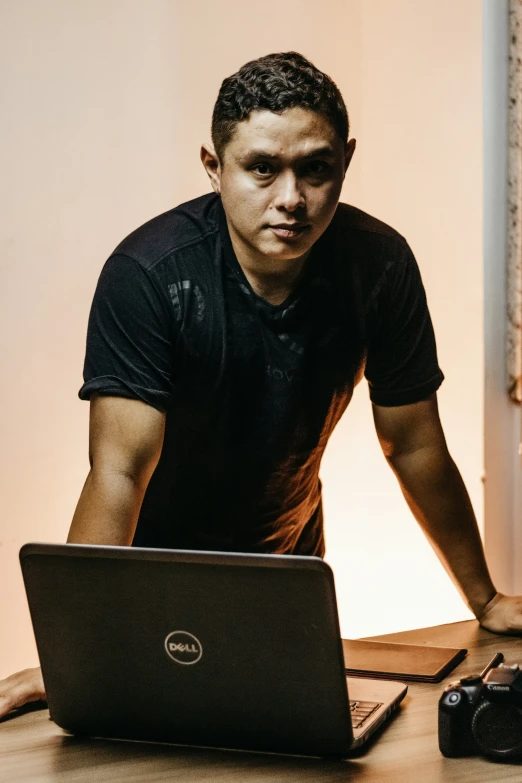 a man looking at a laptop on a table