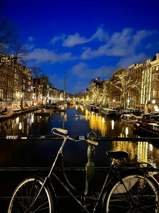 the reflection of a bicycle is visible in a canal