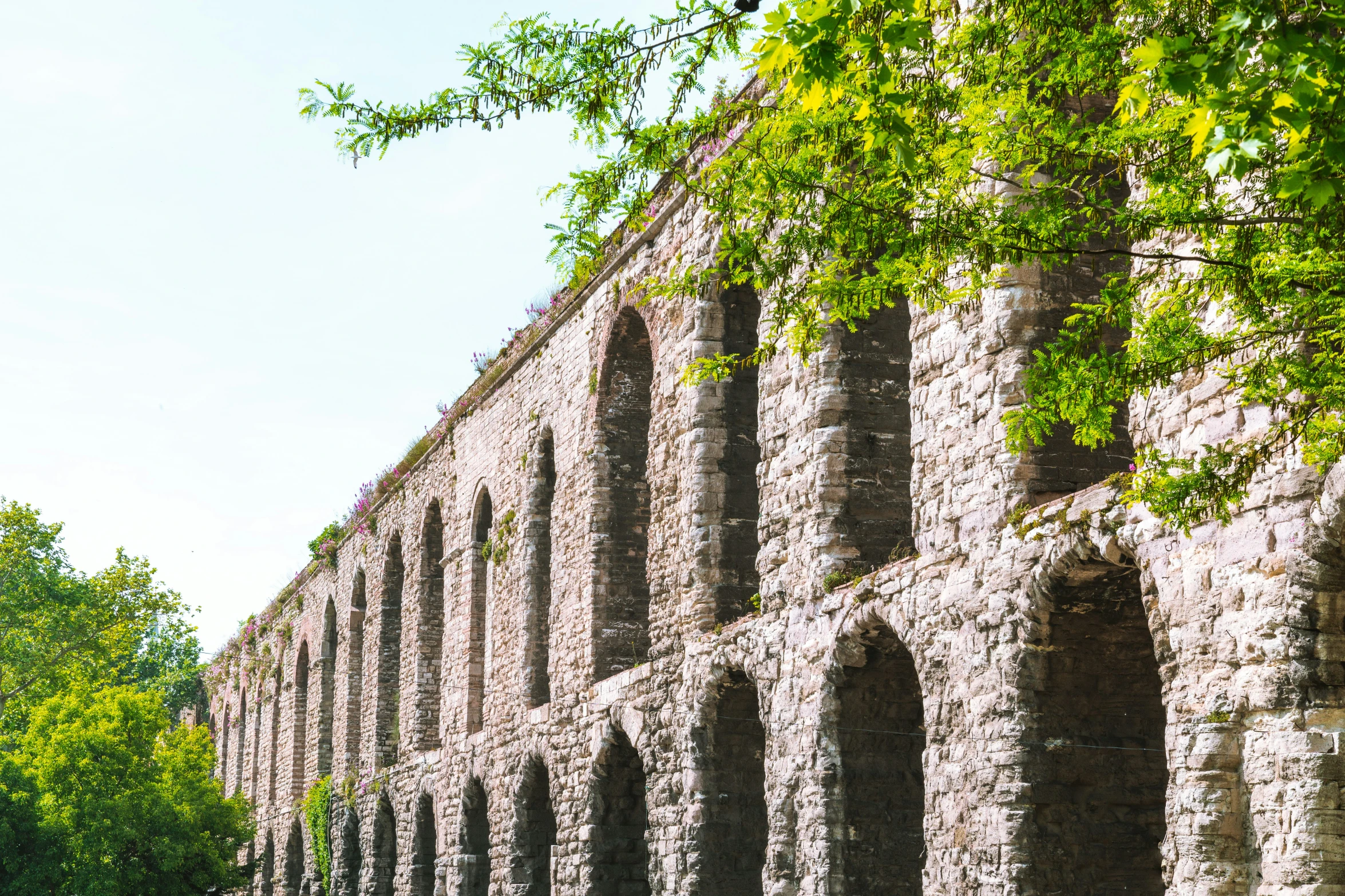 large brick structure with columns and several trees near it