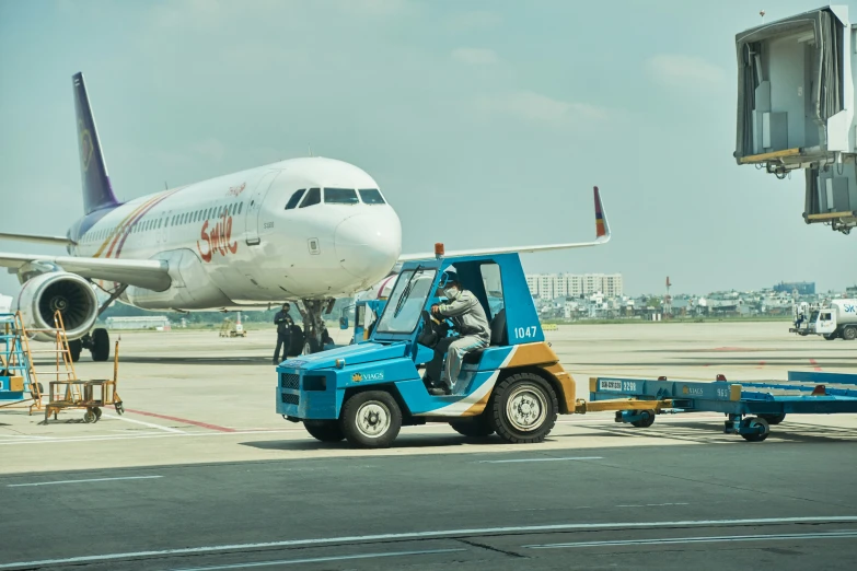 a small truck with a tractor pulls the back of an air plane