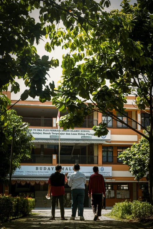 a group of four men walking up a sidewalk