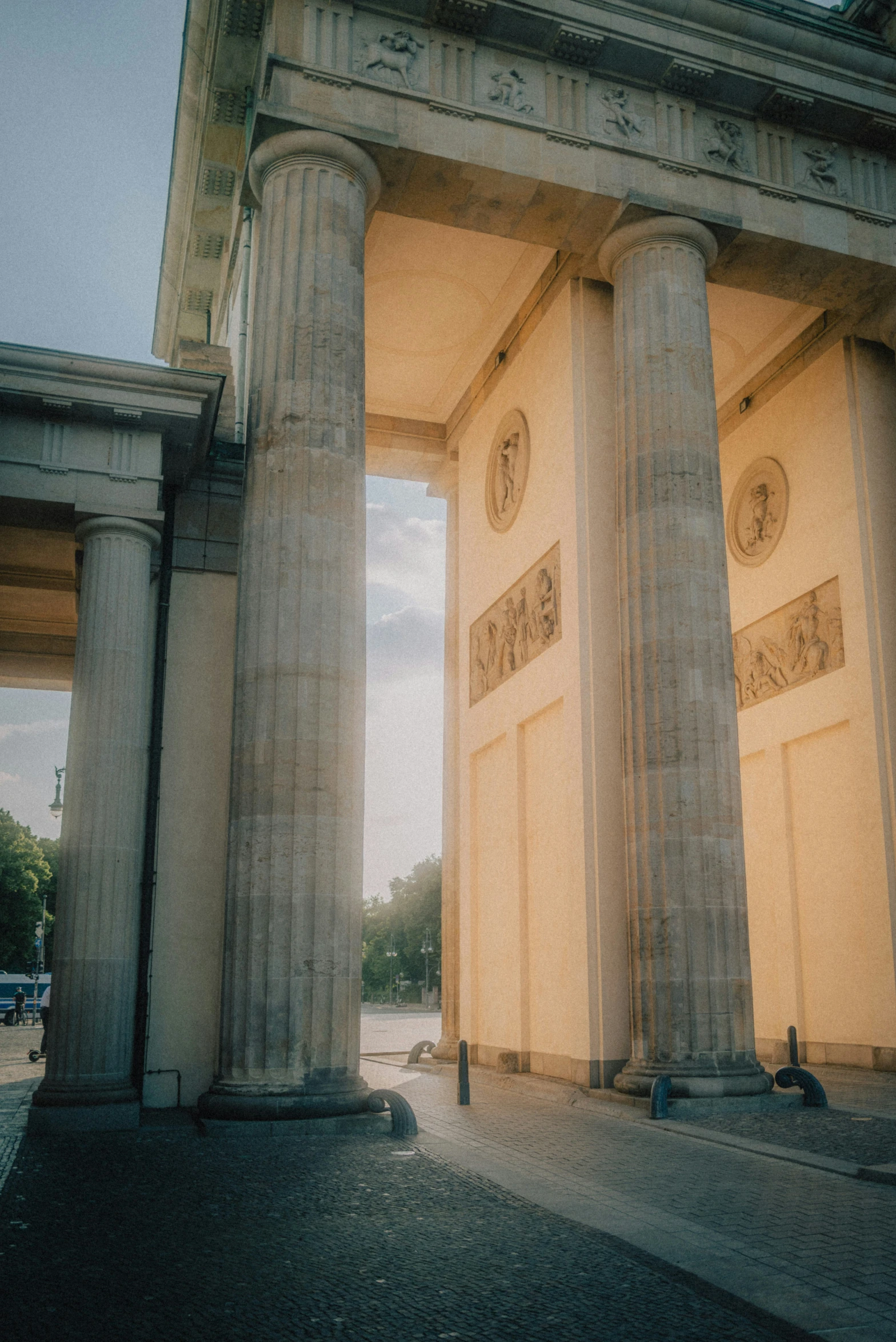 a view of the side of a building, through the columns