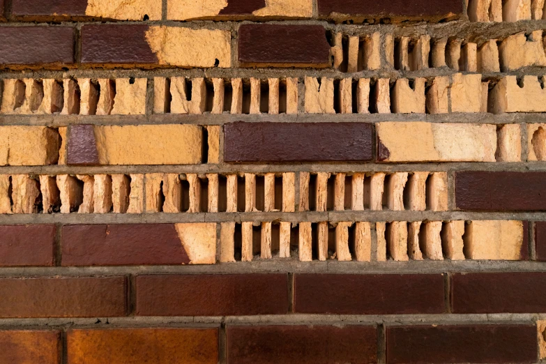 a red and tan brick wall that is next to a green street sign