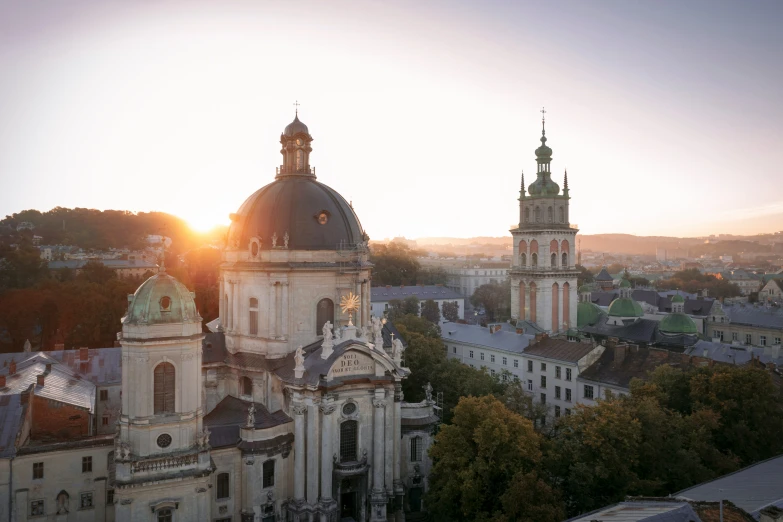 the sun is shining behind old buildings on a city