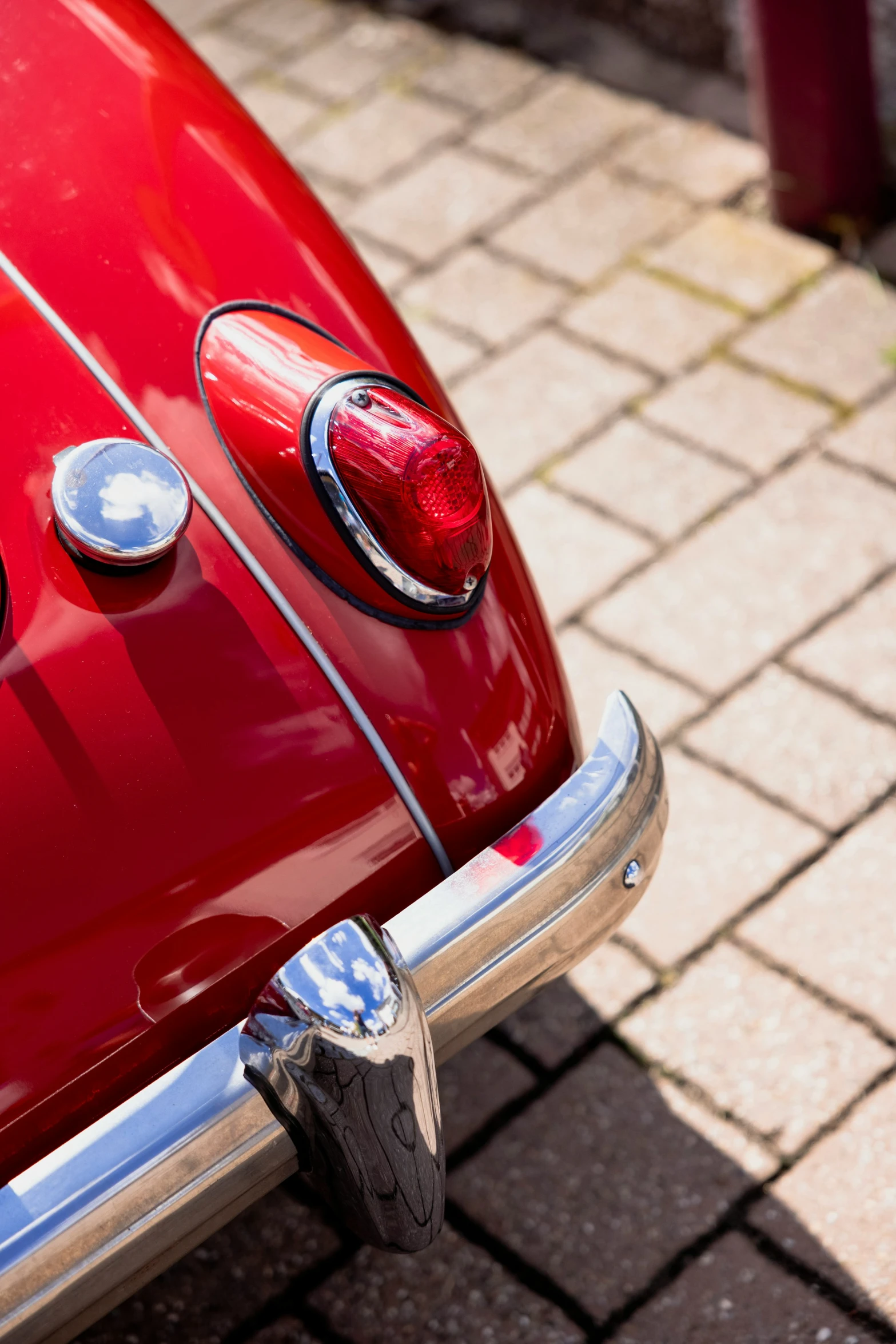 the tail light of a classic car with a silver top