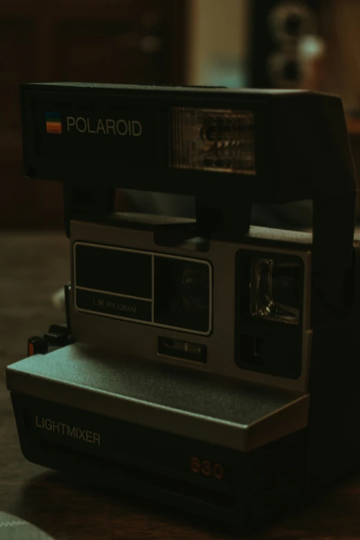 a polaroid camera sits on a wooden table