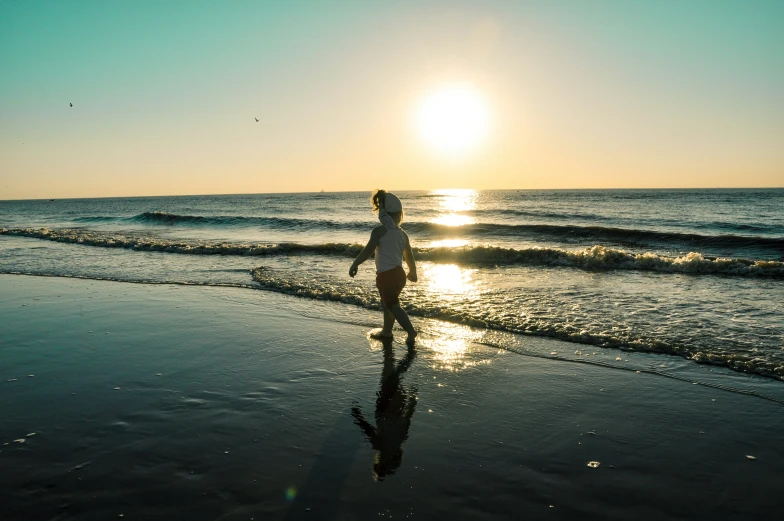 a man standing on a beach next to the ocean