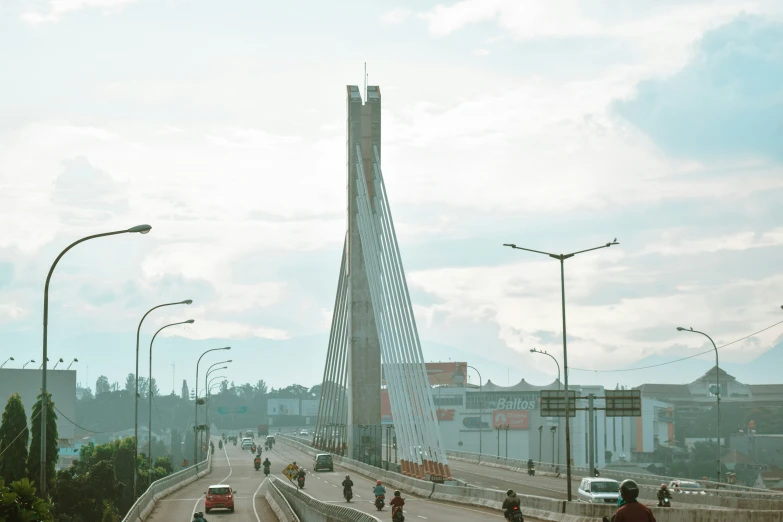 several people on bikes crossing a bridge in an urban setting