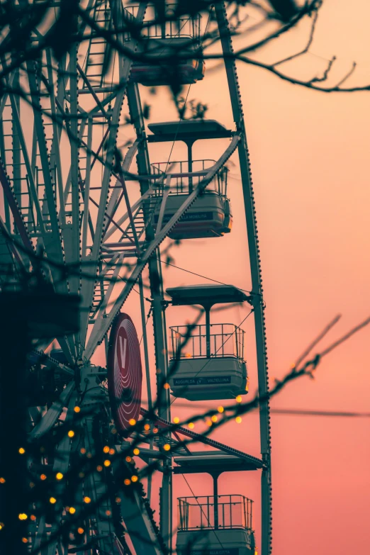 the ferris wheel is in front of a red sky