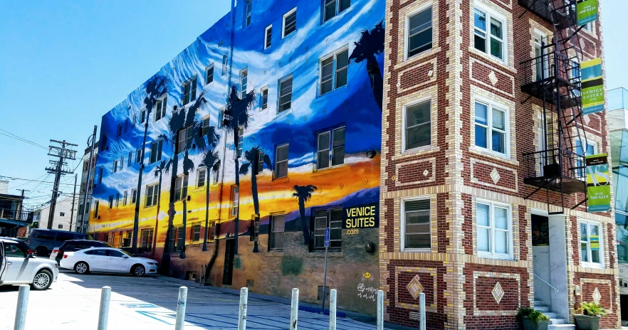 a building on the corner of a street with a large mural