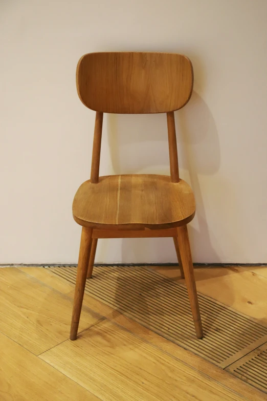 an old wooden chair leaning against a wall