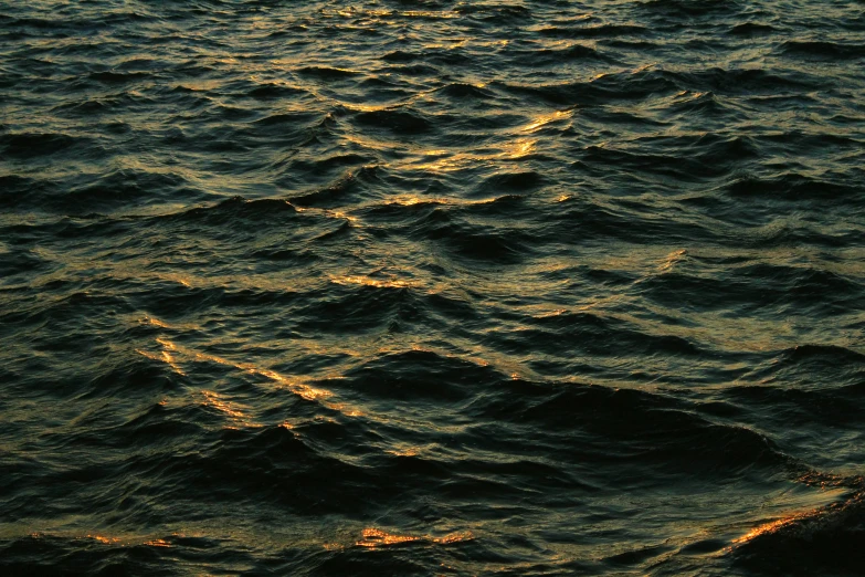 the wake of the ocean wave at sunset