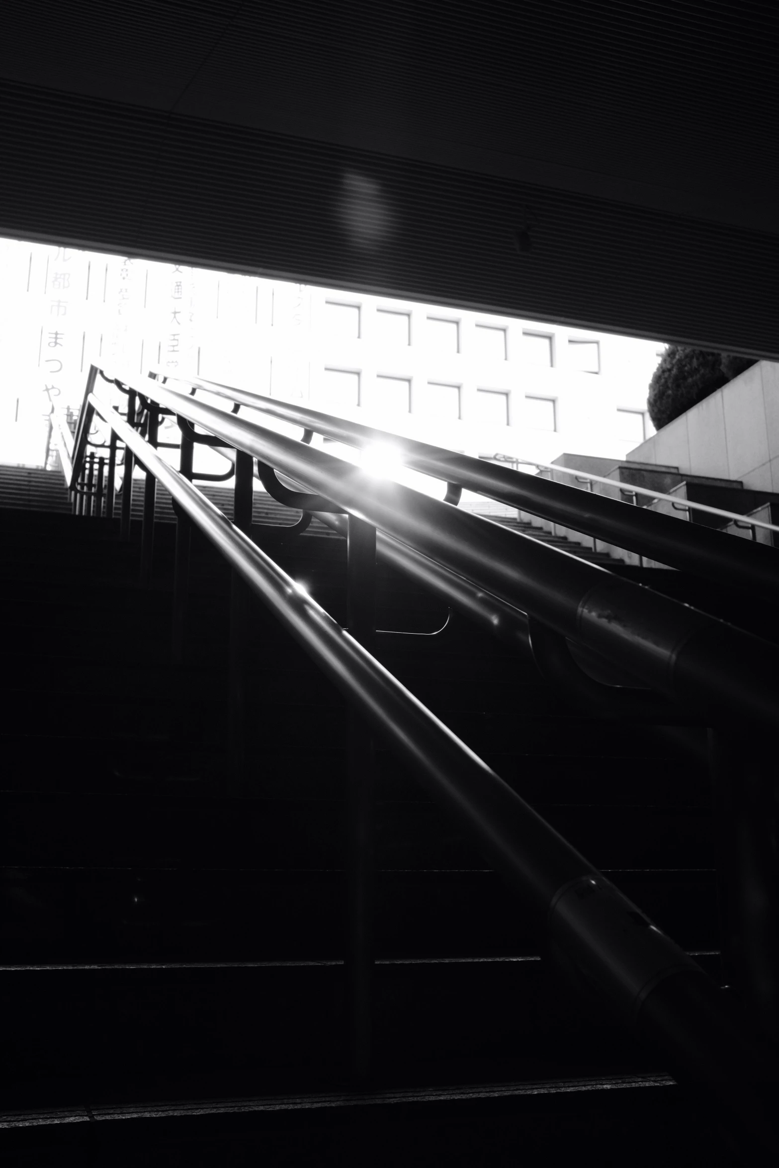 sunlight shines through a window over an escalator