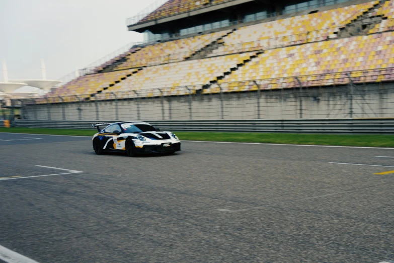 a racing car with a number on it's hood driving on the track