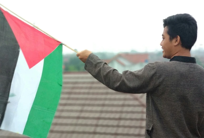 a man holding a flag on the side of his head