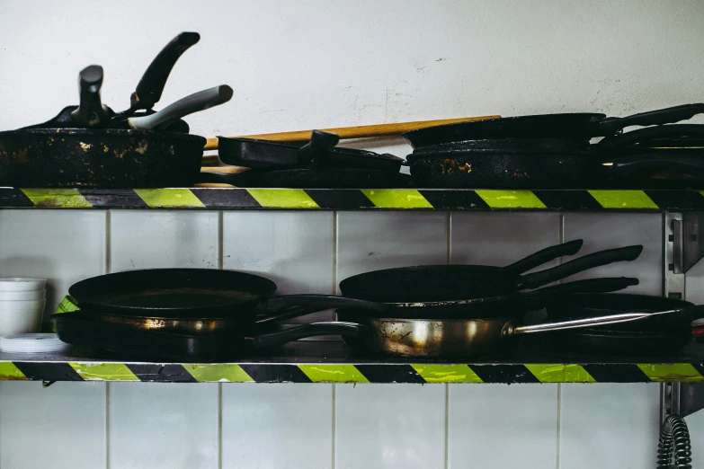 the kitchen counter with a shelf full of various pans