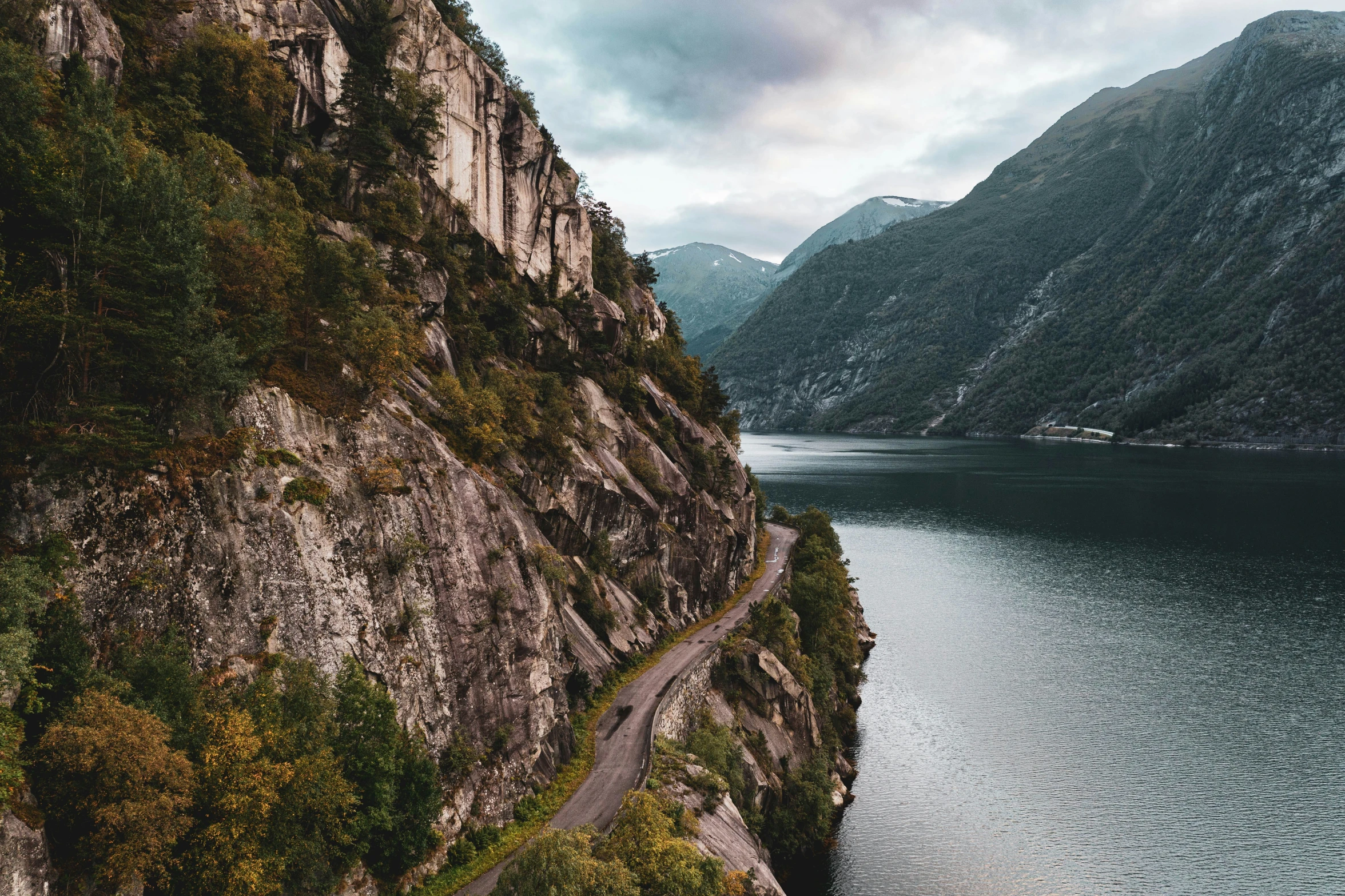 a scenic road on a steep mountain near a body of water