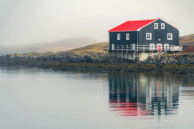 a large black building sitting on top of a mountain next to water