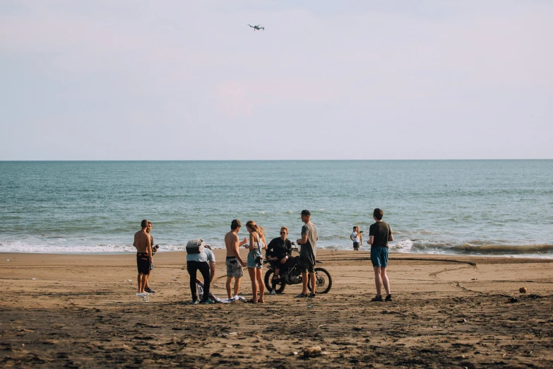 group of people at the beach talking to each other