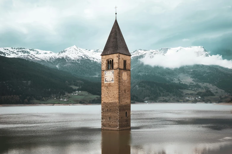 the tower of the church stands in a still water pond