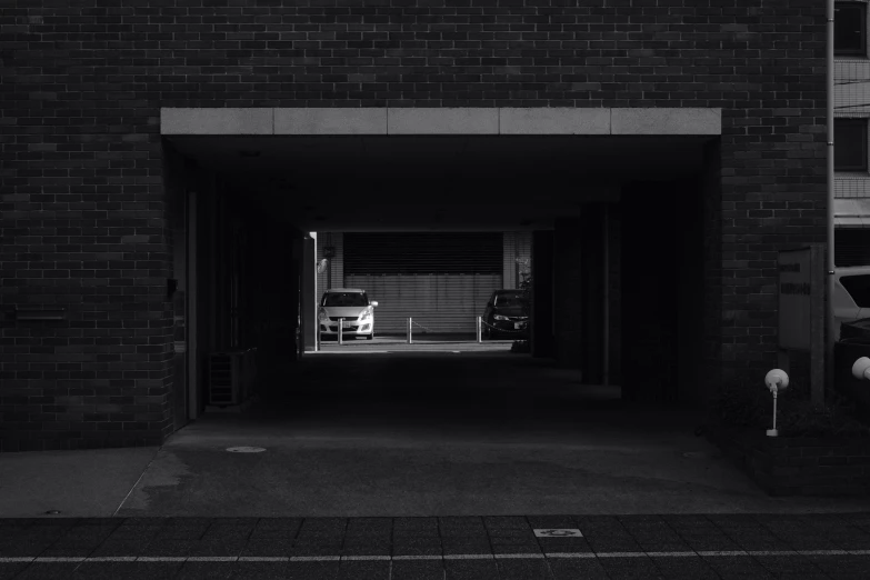 a man sitting at an entrance in an alley