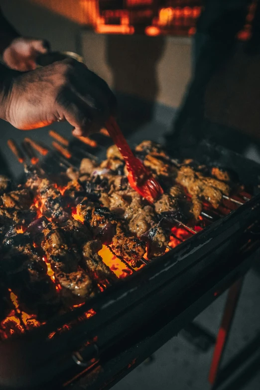 a person cooking some food on an outdoor grill