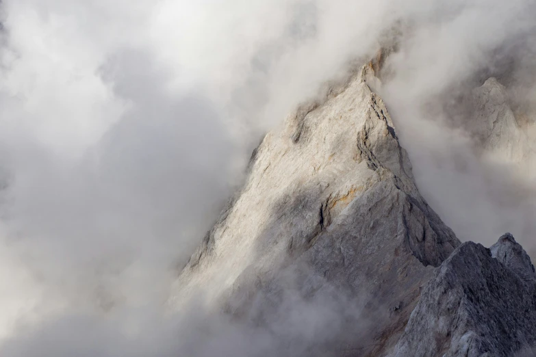 a tall mountain is covered in thick clouds