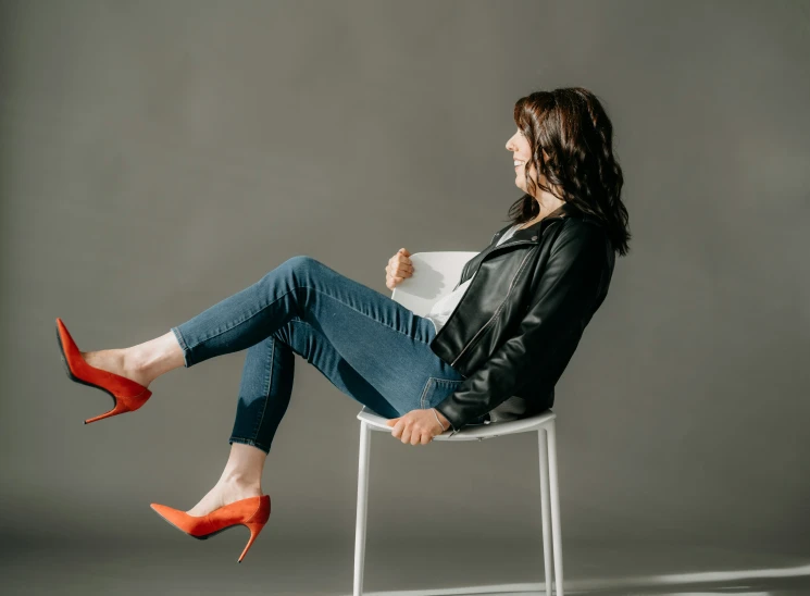 a woman sitting in a chair with high heels