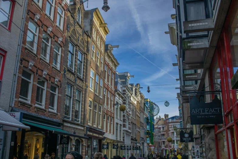 several people walk on the sidewalk between two buildings