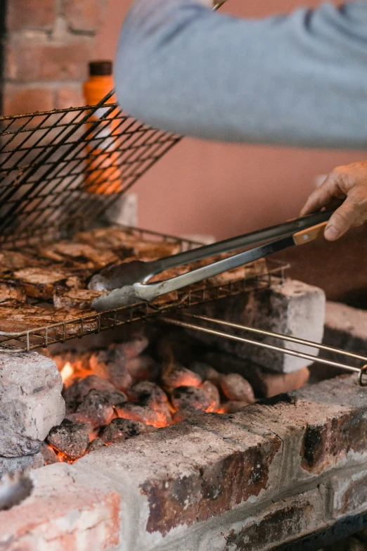 a close up of a person cooking a pizza on a stick over a fire