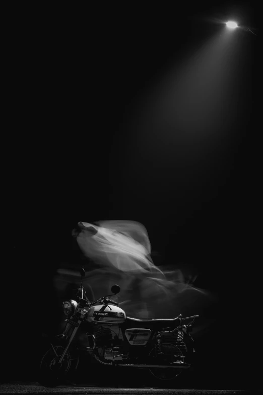 a black and white po of a motorcycle in the dark