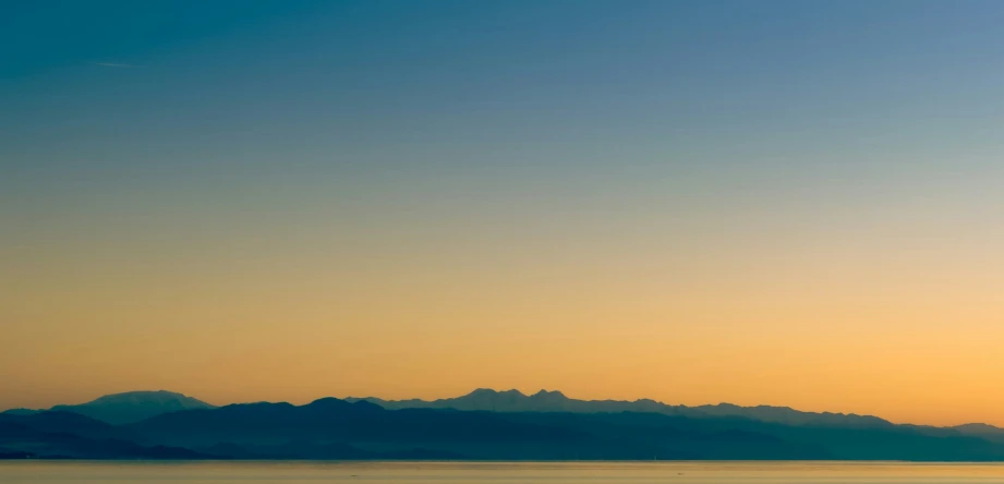 a single plane flies in the sky over water