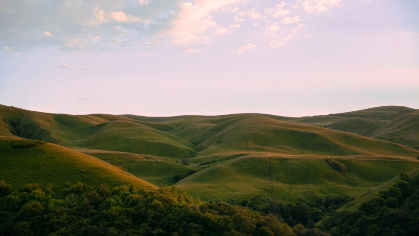 a large field with hills and trees in the background