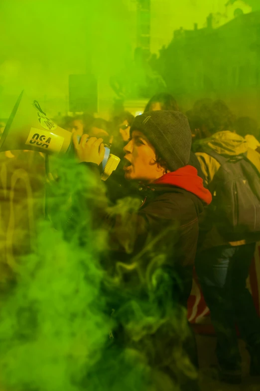 a man is standing in front of a green smoke