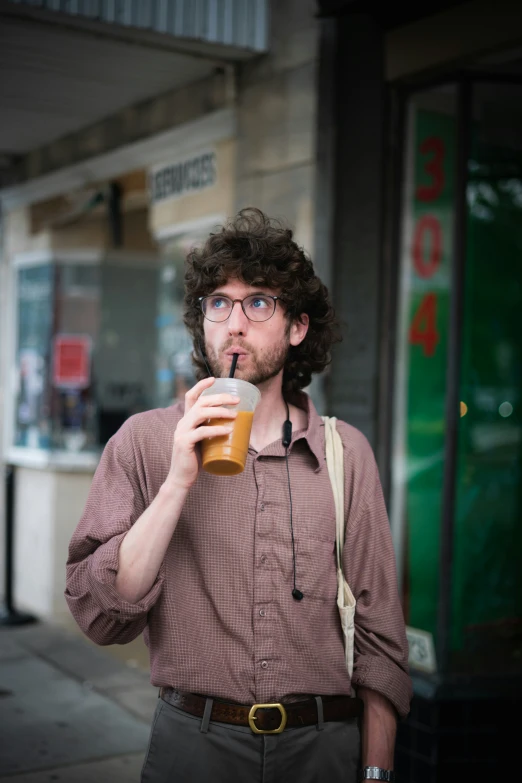 a man that is holding a glass with soing