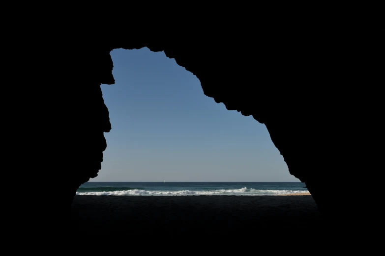 a hole in the side of a building on a beach