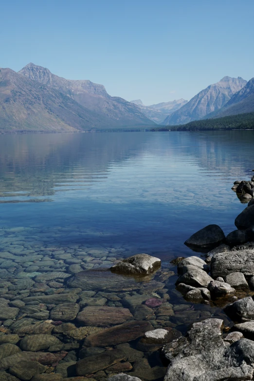 a body of water surrounded by rocks near mountains