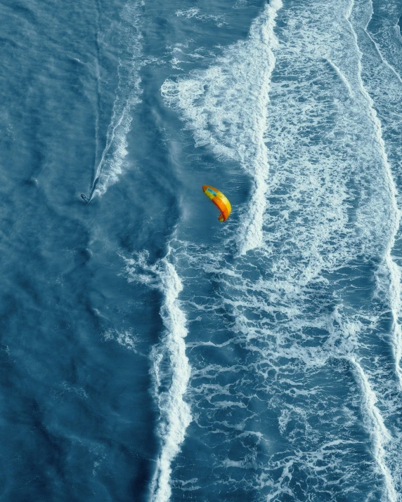 orange object sitting on surf with foamy blue water