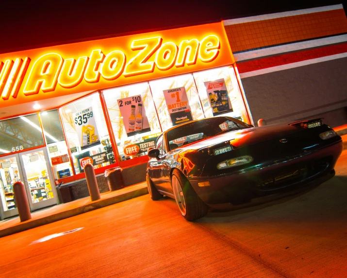 the car is parked next to the neon shop