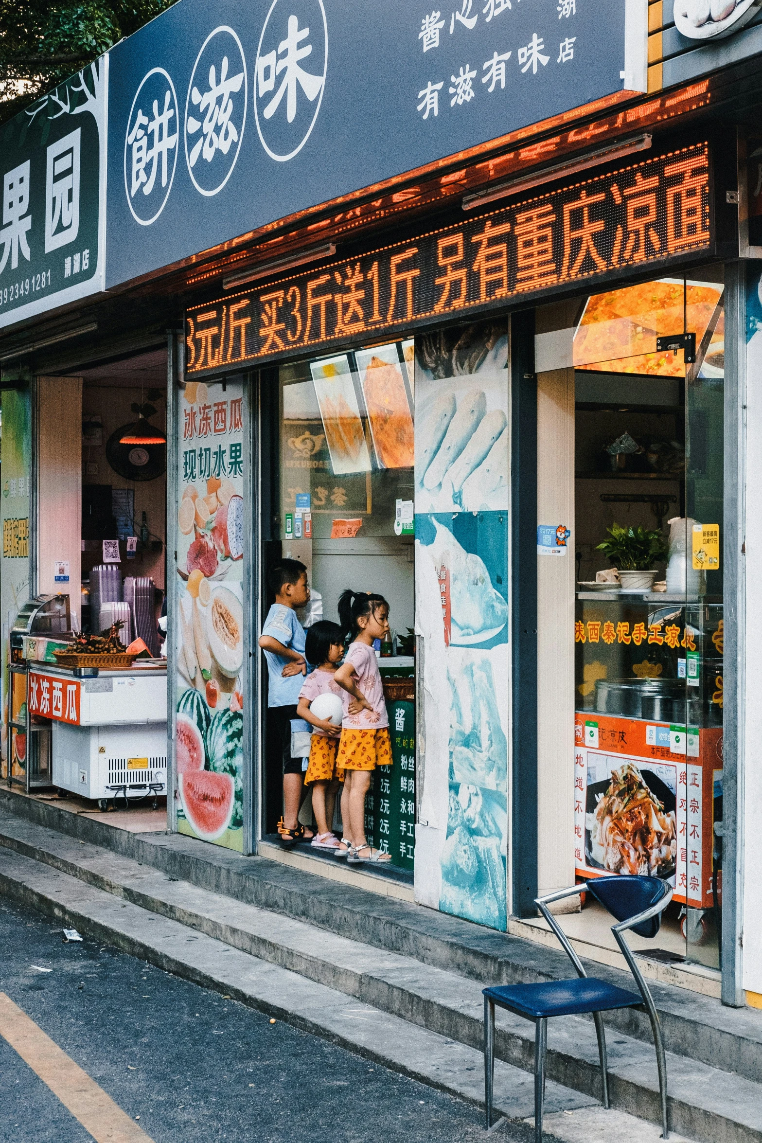 a woman sitting outside of a store with children on her lap