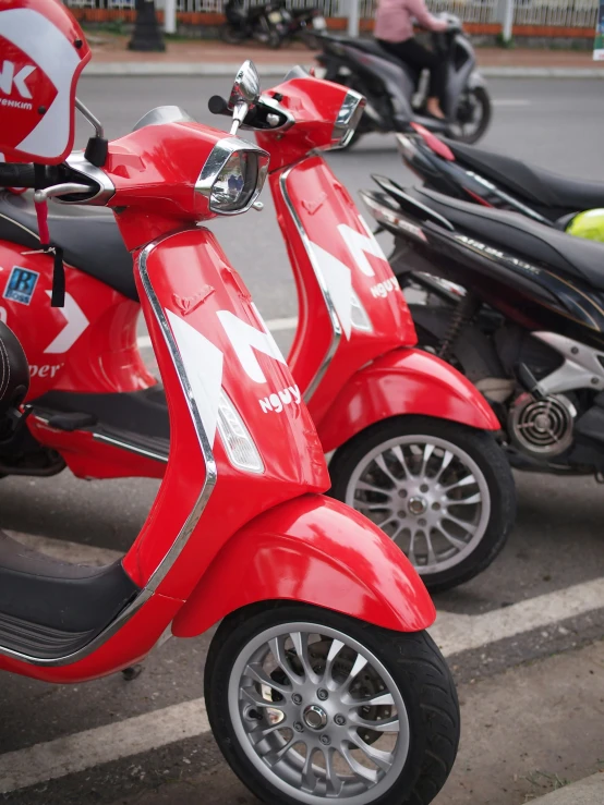 two scooters are parked in a lot next to the street