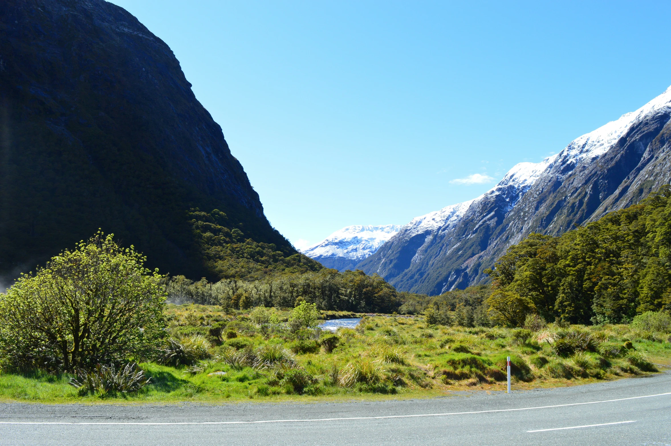 two roads winding through a valley with a mountain range in the background