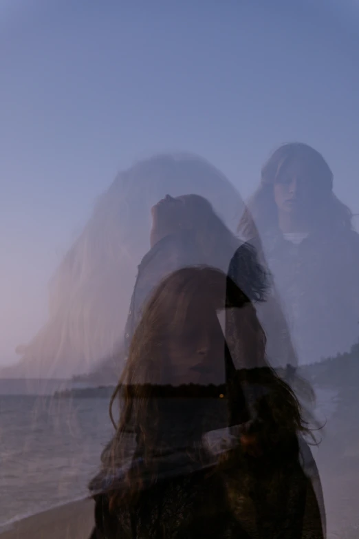 two people standing in front of the ocean