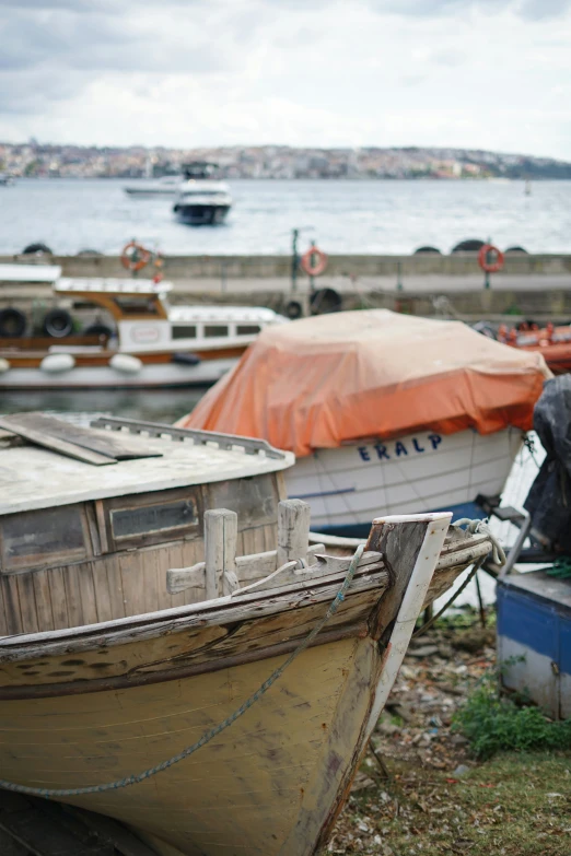 boats are moored and on the shore of a lake